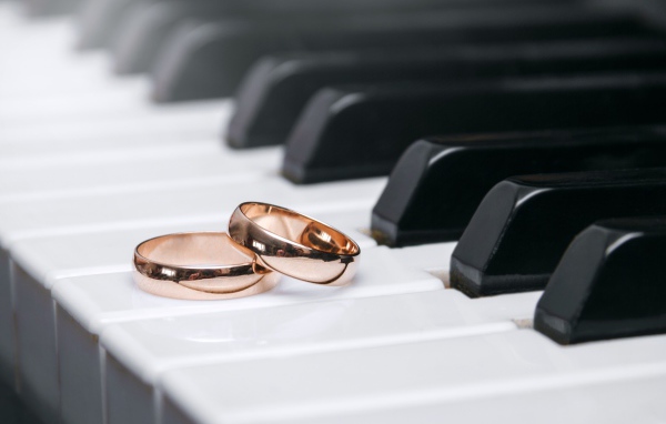 Два золотых обручальных кольца на клавишах рояля 