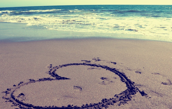 Большое сердце на мокром песке на пляже