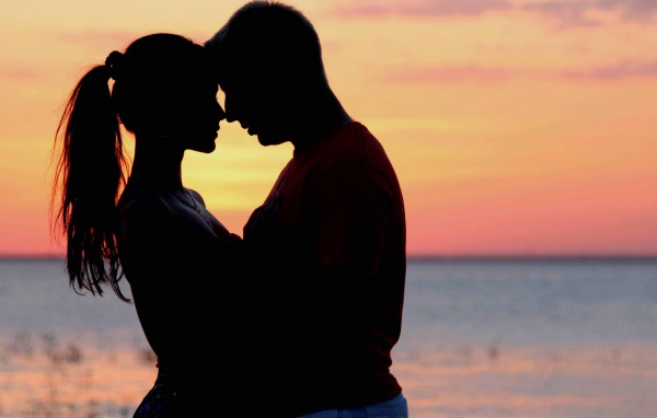 Влюбленная пара на фоне моря в сумерках 