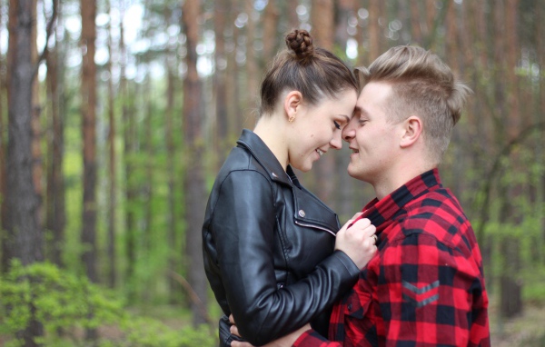 Влюбленная пара стоит в лесу 
