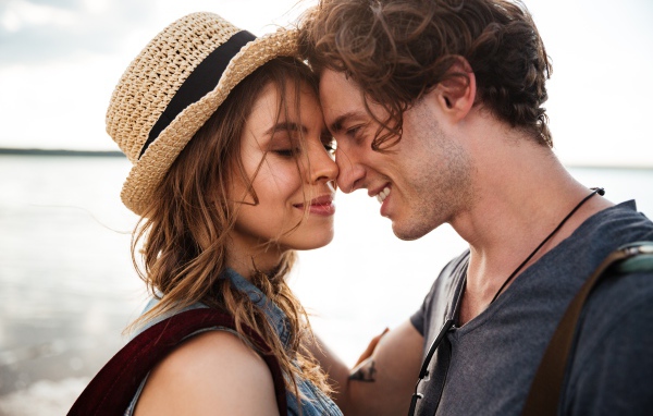 Влюбленная пара стоит на фоне моря 