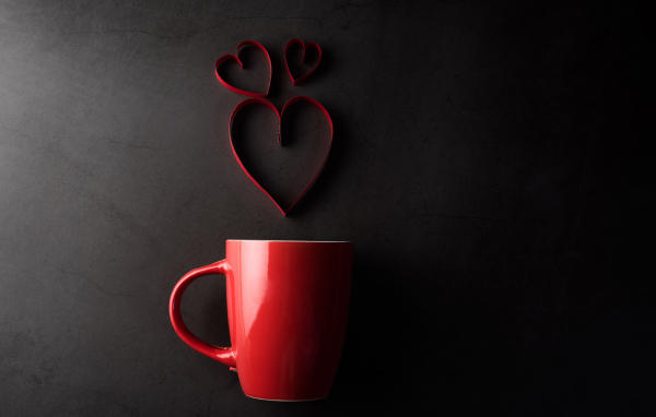 Красная чашка на сером фоне с сердечками