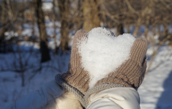 Снег в руках у девушки в перчатках 