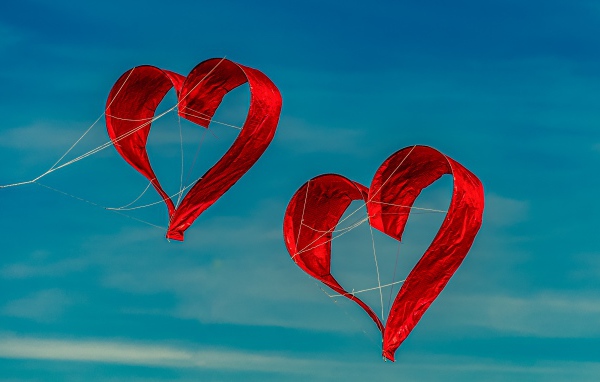 Two heart shaped kites in the sky