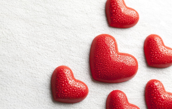 Мокрые красные сердечки на белом фоне