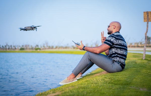 A man launches a quadrocopter over the lake