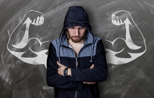 Мужчина с часами на руке грустит у стены