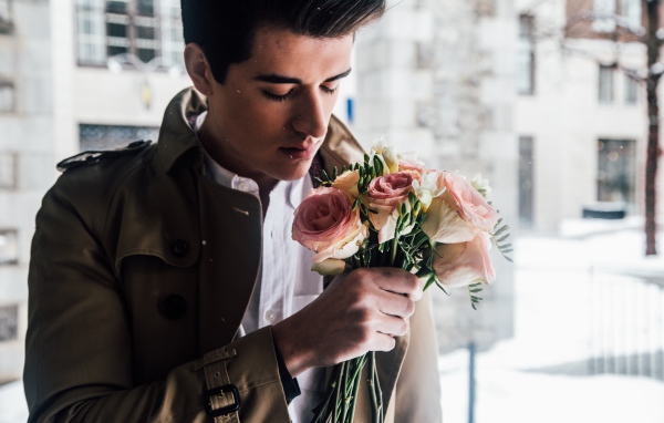 Красивый мужчина с букетом роз в руке