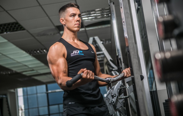 Накаченный мужчина занимается на тренажере в спортзале