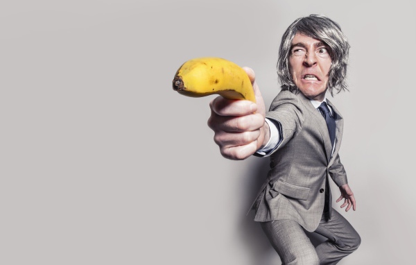 Мужчина в костюме защищается бананом