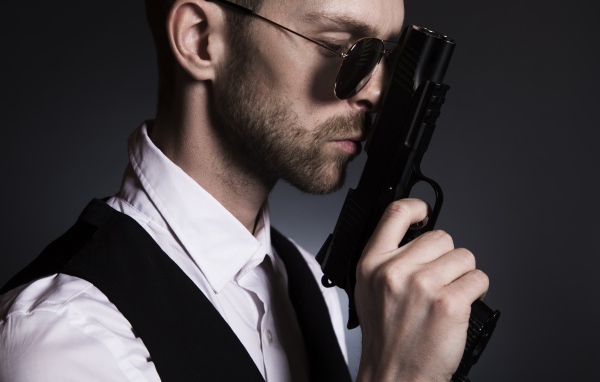 Мужчина в очках с пистолетом в руке