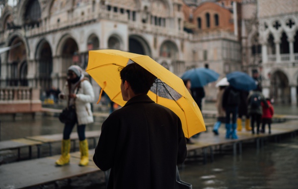 Мужчина с желтым зонтом в городе 