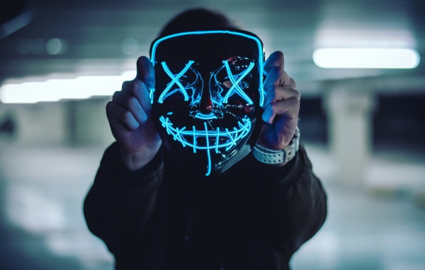 Neon mask anonymous in the hands of a guy