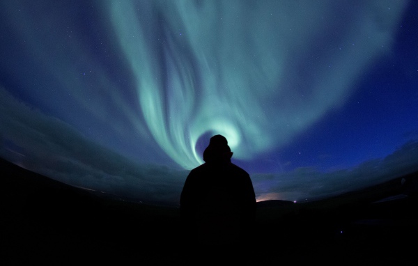 Силуэт мужчины на фоне неба с полярным сиянием