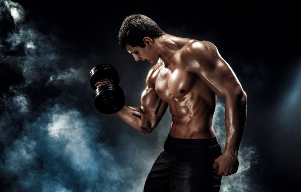 Мужчина тяжелоатлет с гантелей в руке