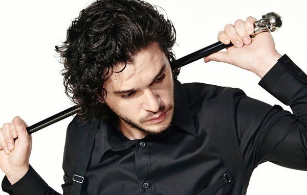 Актер Кит Хэрингтон с тростью в руках на белом фоне