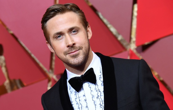 Актер Райан Гослинг в костюме на красном фоне