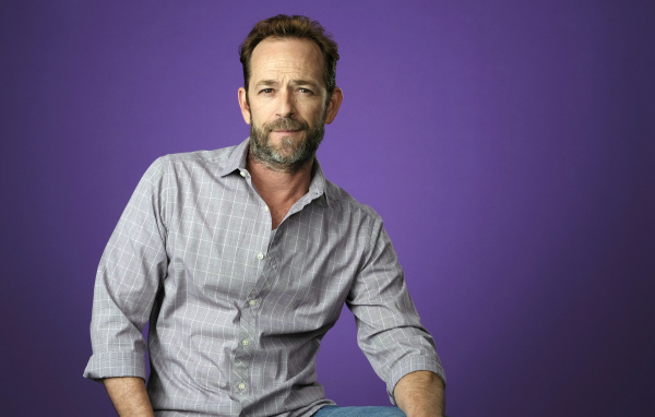 Американский актер Люк Перри в рубашке на сиреневом фоне