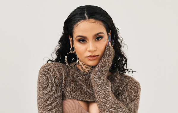 Американская певица Кейлани в свитере на сером фоне