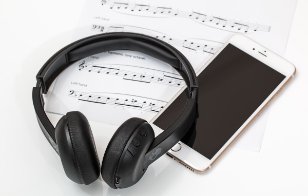 Наушники на столе с нотами и смартфоном