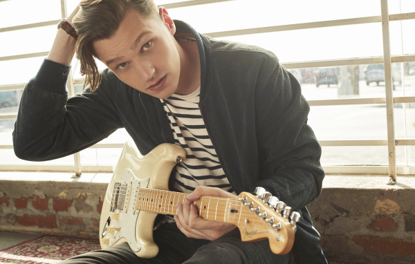 Певец Патрик Дрони с гитарой в руках