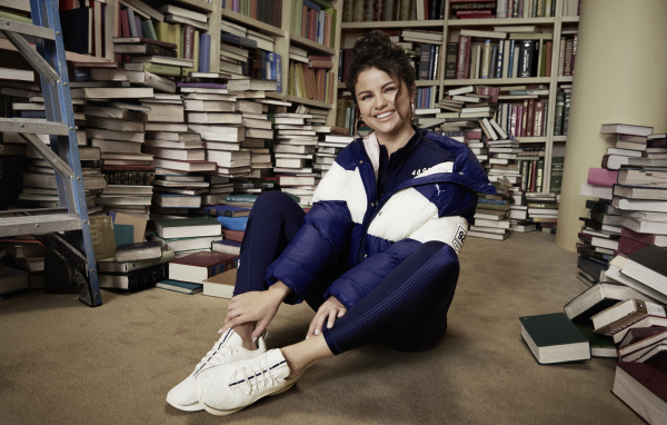 Улыбающаяся певица Селена Гомез в библиотеке 