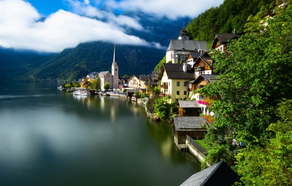 Красивые дома на берегу спокойного озера у подножия гор 