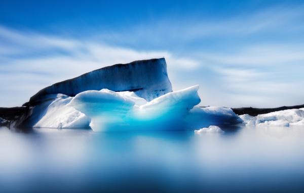 Большой синий айсберг в океане на фоне неба