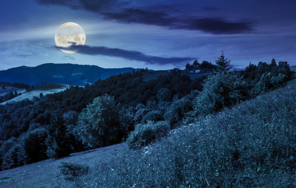 Big moon in the night sky over the hills