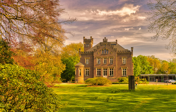 Большой трехэтажный дом в зеленом парке
