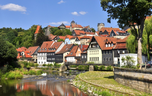 Много домов у пруда на фоне голубого неба