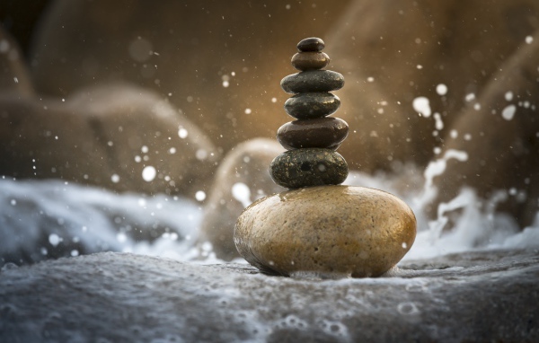 Гладкие мокрые камни в белой морской пене 