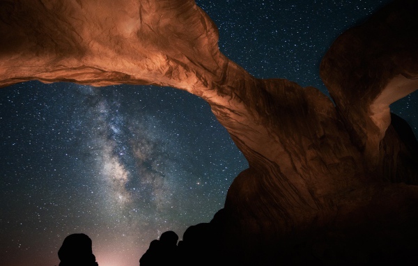 Каменная природная арка под звездным небом ночью 