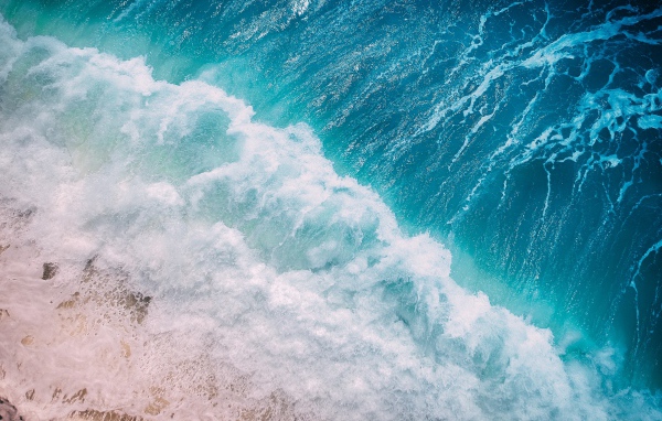 Бурные белые волны океана на песке 