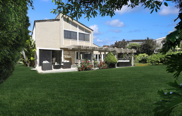 Двухэтажный дом с зеленым газоном 