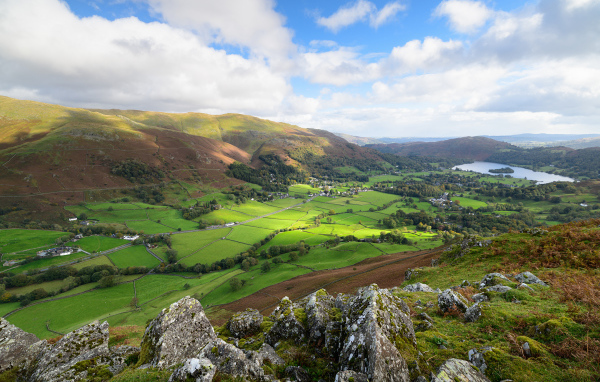 Вид на зеленые холмы под голубым небом с белыми облаками летом