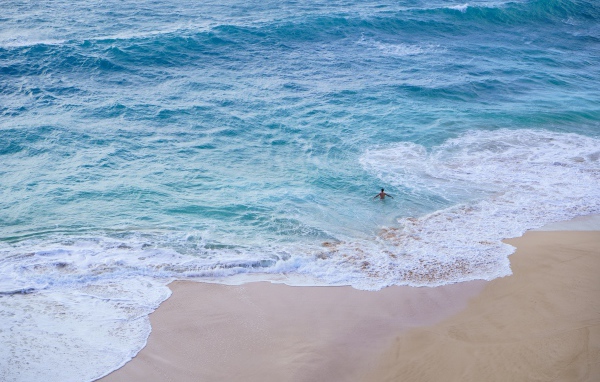 Голубая вода океана на пляже с желтым песком