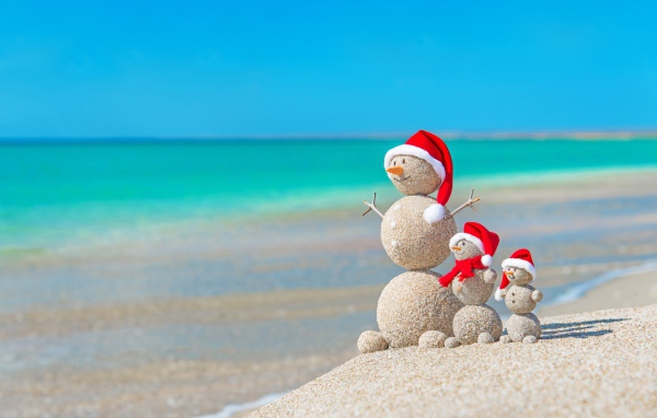 Снеговики из песка на берегу океана 