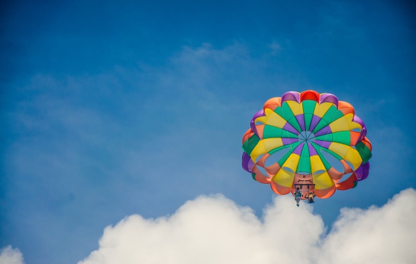 Парашют в голубом небе с белыми облаками