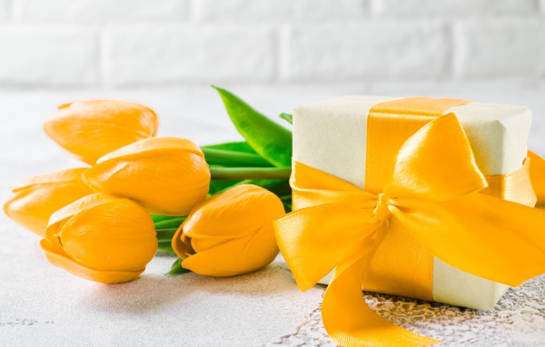 Красивый букет желтых тюльпанов с подарком