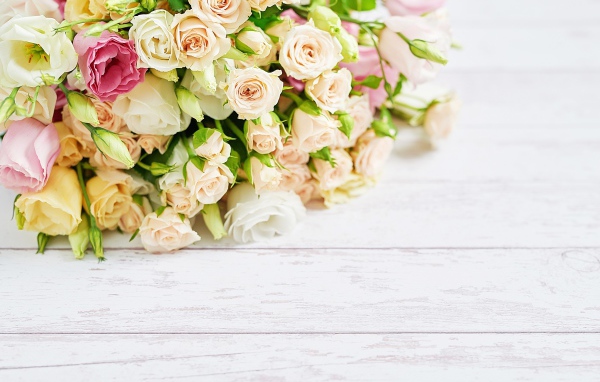 Красивый большой букет роз на белом столе