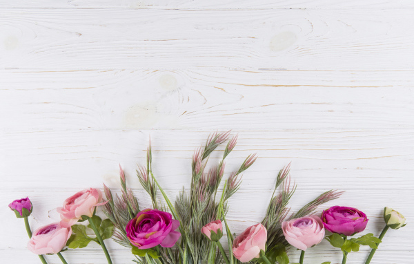 Букет разноцветных лютиков на белом столе