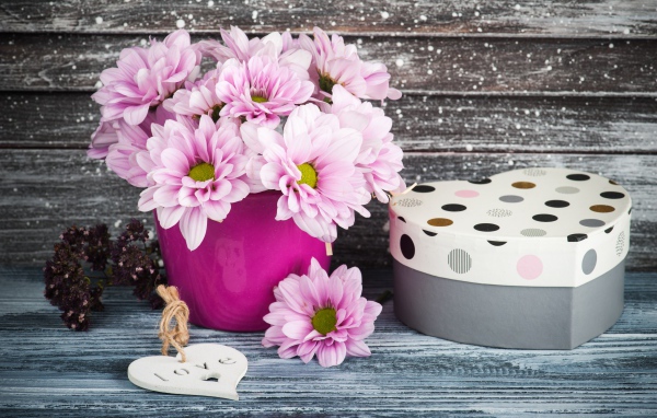Букет розовых цветов хризантемы на столе с коробкой 