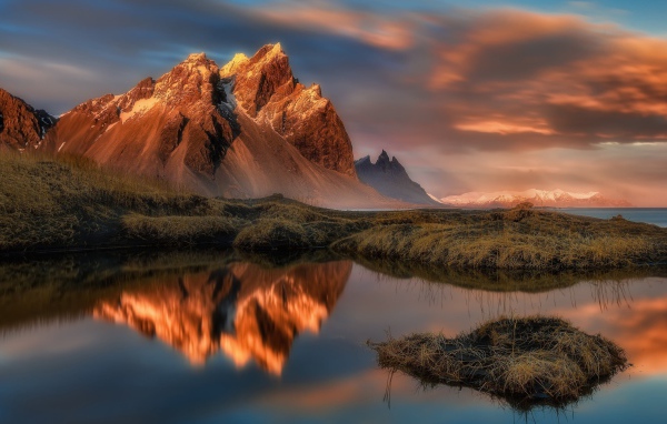 Красивое розовое небо над заснеженными горами у залива 