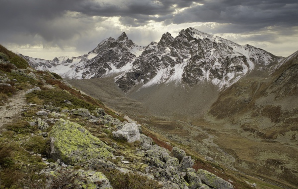 Высохшая река в горах под грозовым небом