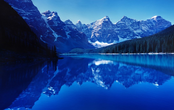 High snow-capped mountains are reflected in the water of the lake