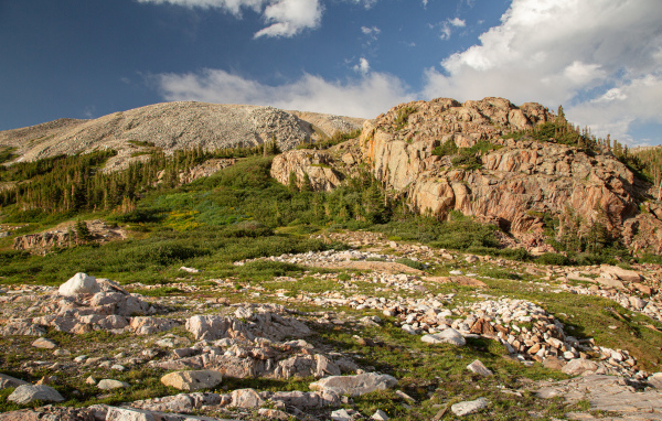 Высокие каменные горы под  голубым небом с белыми облаками