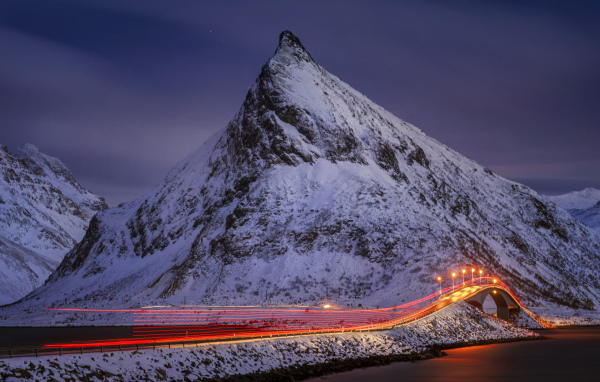 Ночная дорога у заснеженных гор 