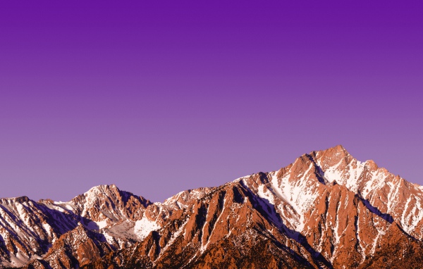 Вершины заснеженных гор на фоне сиреневого заката