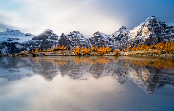 Заснеженные горы отражаются в воде озера 